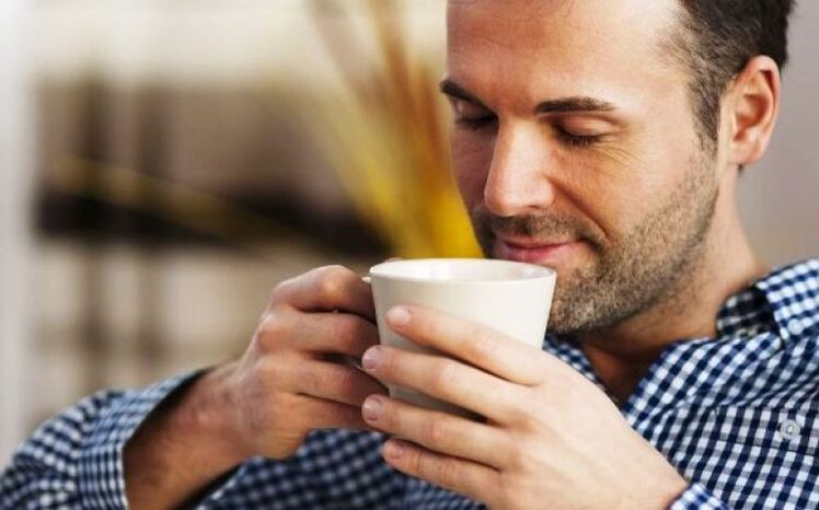 Un bărbat bea o băutură de ceai de fireweed pentru a crește potența